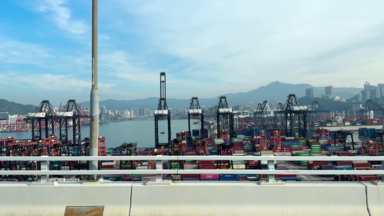 un recorrido diurno por el concurrido puerto de hong kong con grúas de pórtico y numerosos contenedores