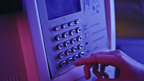 neon woman hand calling payphone at call box closeup. lady pressing buttons
