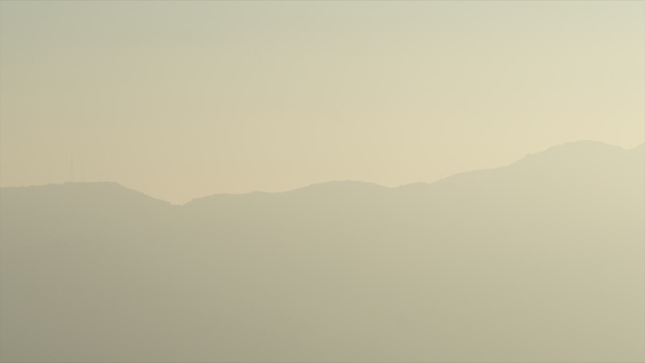 산 뒤로 해가 지는 패닝 시간 경과와 무거운 분위기