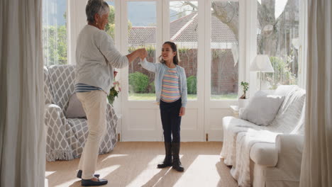 Fröhliches-Mädchen-Tanzt-Spielerisch-Mit-Oma-Und-Hat-Spaß-Beim-Tanzen-Mit-Enkelin,-Die-Das-Familienwochenende-Zu-Hause-Feiert-4k