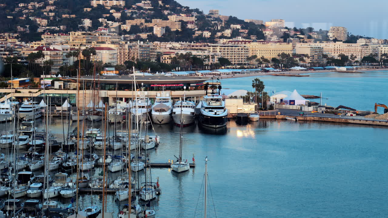 Cannes, Francia - 15 marzo 2025: vista di diverse barche ormeggiate nel porto turistico di Cannes con gli edifici della città sullo sfondo al tramonto
