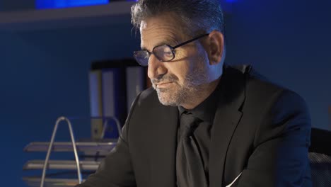 businessman in glasses works with laptop in office.
