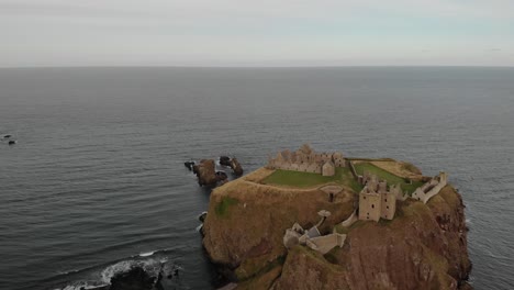 drone-a-sweeping-view-of-the-ocean-before-revealing-Dunnottar-Castle-perched-in-Scotland