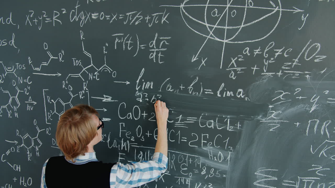Teacher/Student working on equations on a chalkboard