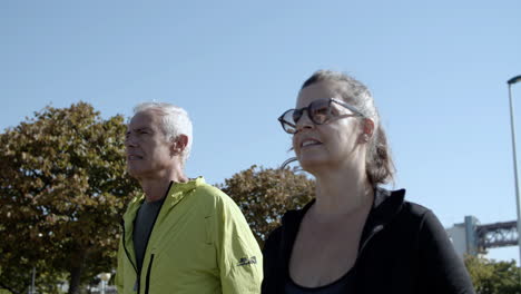 couple of mature runners jogging down street