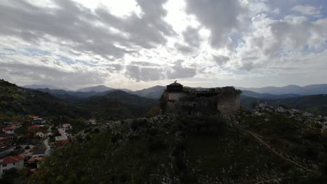 epic stronghold: ancient petrela castle, a timeless battleground perched on a rocky hill, amidst dramatic skies and gloomy clouds