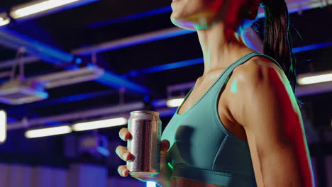 woman drinking sports drink in gym
