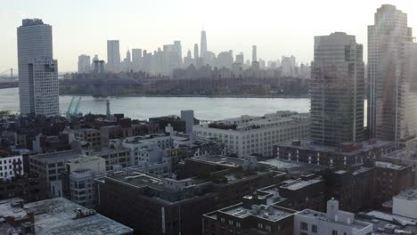 el horizonte de manhattan desde brooklyn durante el atardecer drone disparó pan up diapositiva 4k aeiral