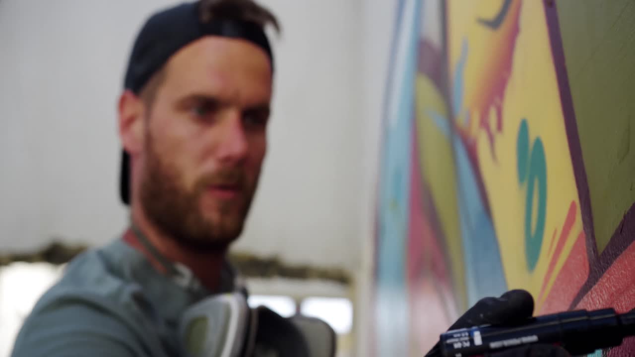 Graffitaro che dipinge con un pennarello sul muro 4k