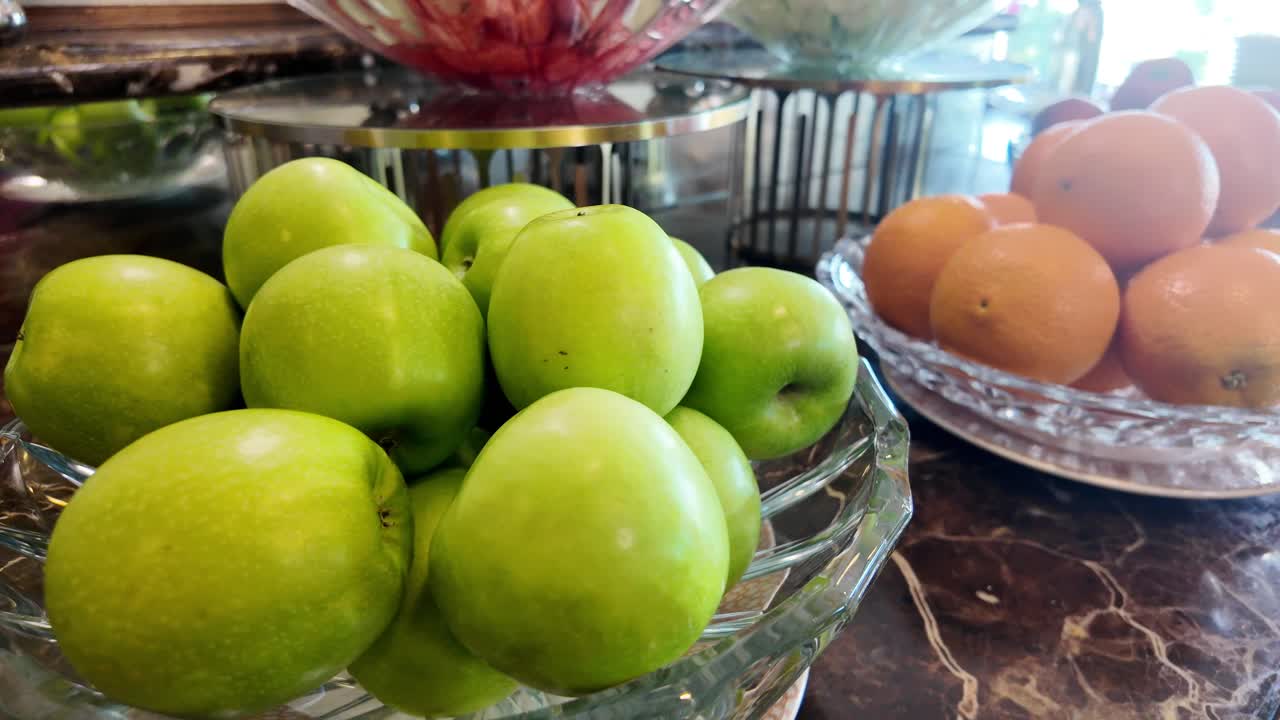 Fresh Green Apples and Oranges Displayed at a Buffet
