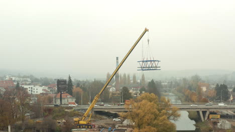 New-bridge-segment-hanging-from-mobile-crane-above-busy-city-highway