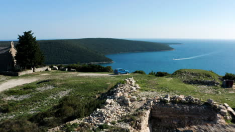 blue sportback car positioned at kamenjak peninsula overlooking adriatic sea in istria, croatia