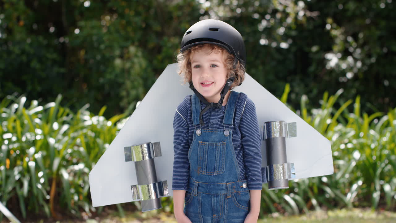 un niño lindo con alas de avión de juguete un niño feliz jugando a un juego fingiendo volar imaginando la libertad de viajar divirtiéndose al aire libre en un parque soleado disfrutando de la infancia