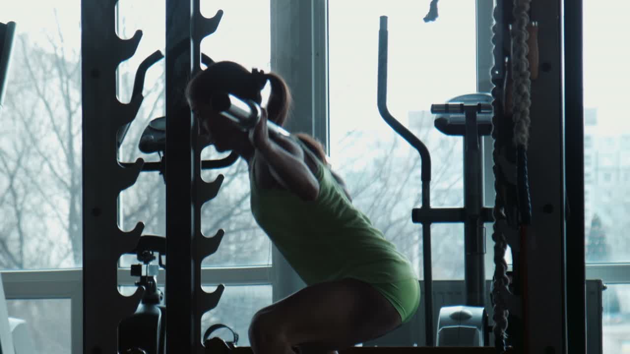 체육관 에서 웨이트 리프팅 을 하는 여자