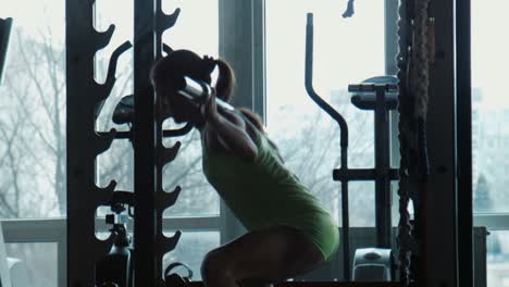 mujer levantando pesas en un gimnasio