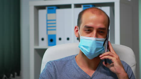 Portrait-of-man-with-mask-talking-on-phone