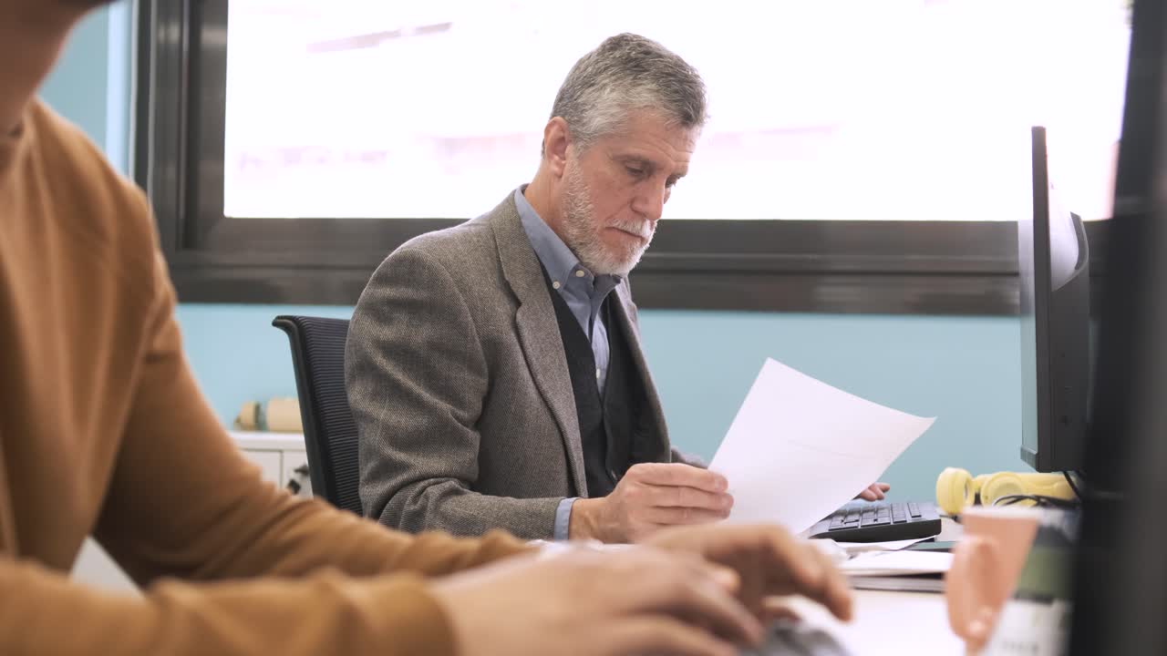 Manager analyzing documents and using computer at coworking workspace