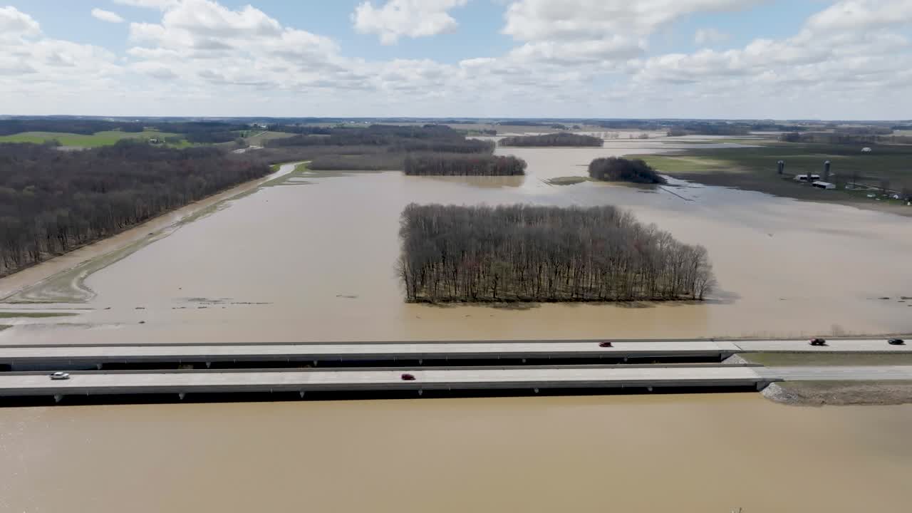 Flooded area in southern Indiana farmland next to freeway with drone video wide shot pulling back