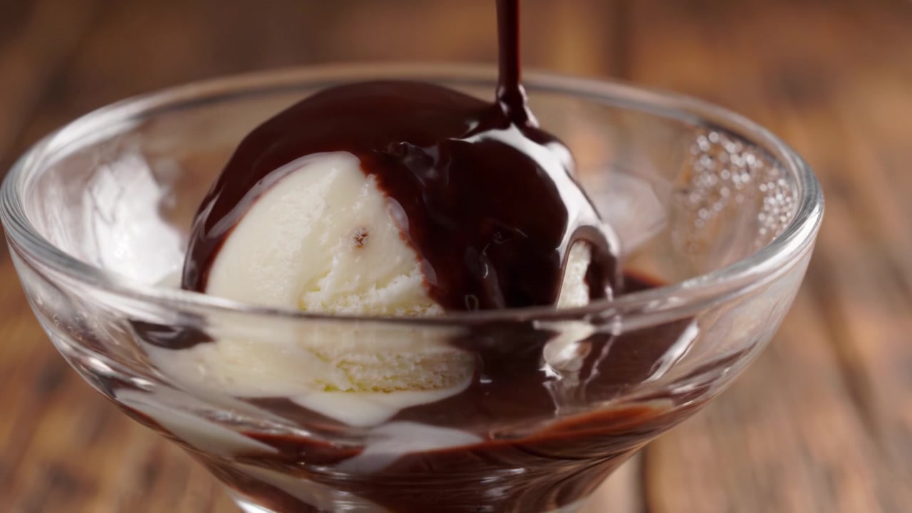 Squisito Dessert Goloso: Gelato Cremoso alla Vaniglia Ricoperto da Ricca Salsa al Cioccolato Servito in una Raffinata Coppa di Vetro, Perfetto per Concedersi un Piacere