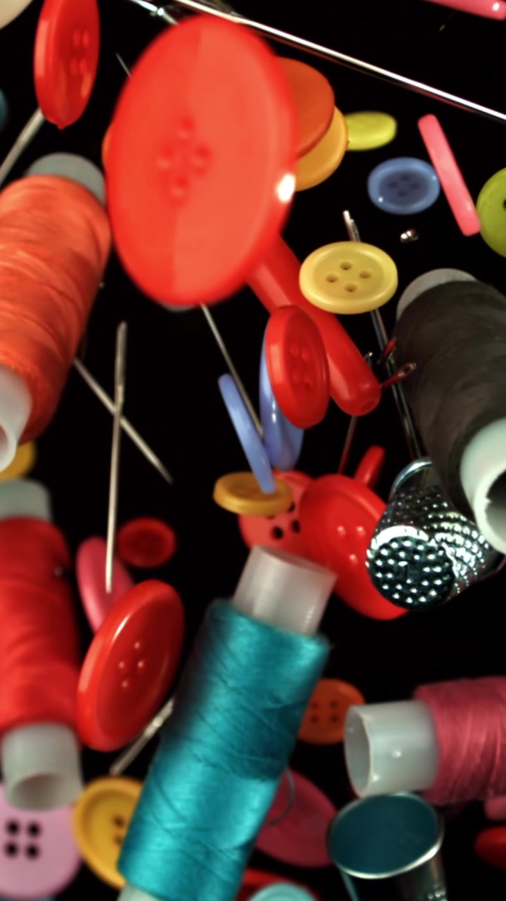 Vibrant Sewing Buttons, Thread, and Needles Floating in Slow Motion