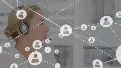 Animation of network of connections and icons over businesswoman wearing headset
