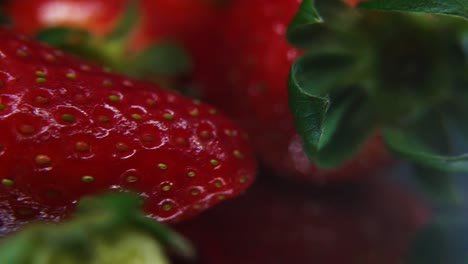 macro detailed video of a pile of strawberries, red strawberry, green leaf, tiny seeds, on a rotating stand, smooth movement