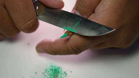 Footage-of-hands-slowly-sharpening-a-pencil-and-some-coloured-pencils-with-a-sharp-knife