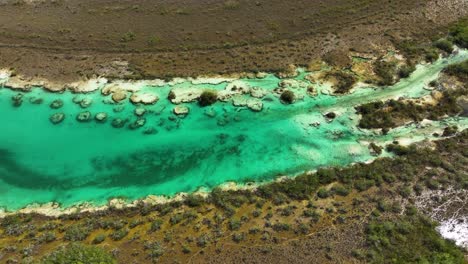 aerial view of vibrant water and stromatolites formations, at the rapidos de bacalar in mexico - tracking, drone shot