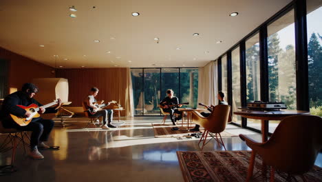 two men playing guitars in modern home studio