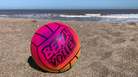 Ein-Bunter-Volleyball-Am-Strand-Mit-Dem-Ozean