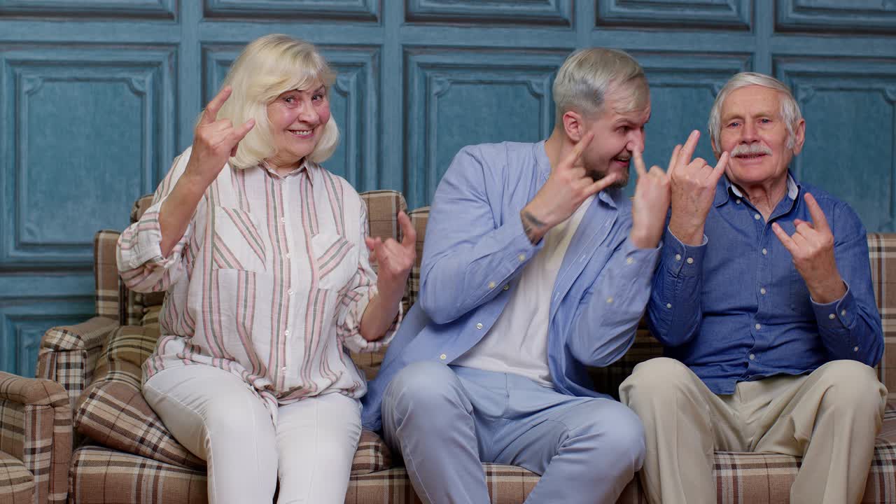 성인이 된 아들과 함께 음악을 듣고 집에서 춤을 추는 노인 할아버지와 할머니의 행복한 세대 가족