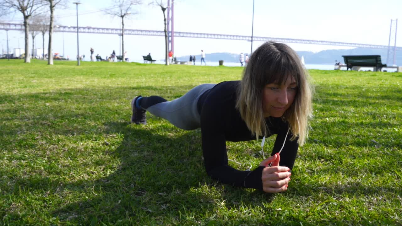 concentrada chica deportiva haciendo ejercicio de tabla en el césped