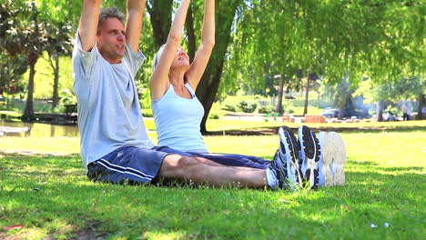 pareja estirándose juntos en el parque