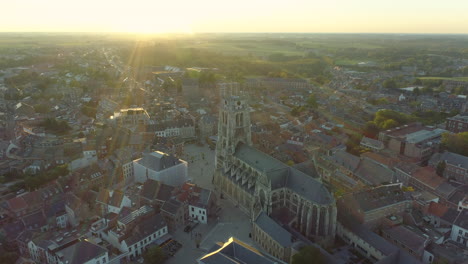 Aerial-View-of-Cathedral,-Basilica-of-Our-Lady-in-Tongeren,-Belgium-with-Sun-Flare
