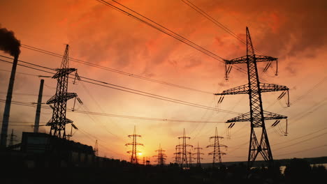 electricity distribution station at sunset. high steel electric towers with wires on bright evening sky backdrop. hi-voltage power lines. rising up.
