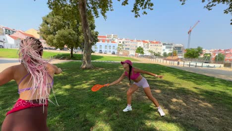 women playing badminton in a park