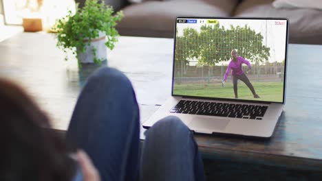 video de una persona sentada en el sofá y viendo un partido de fútbol en una computadora portátil