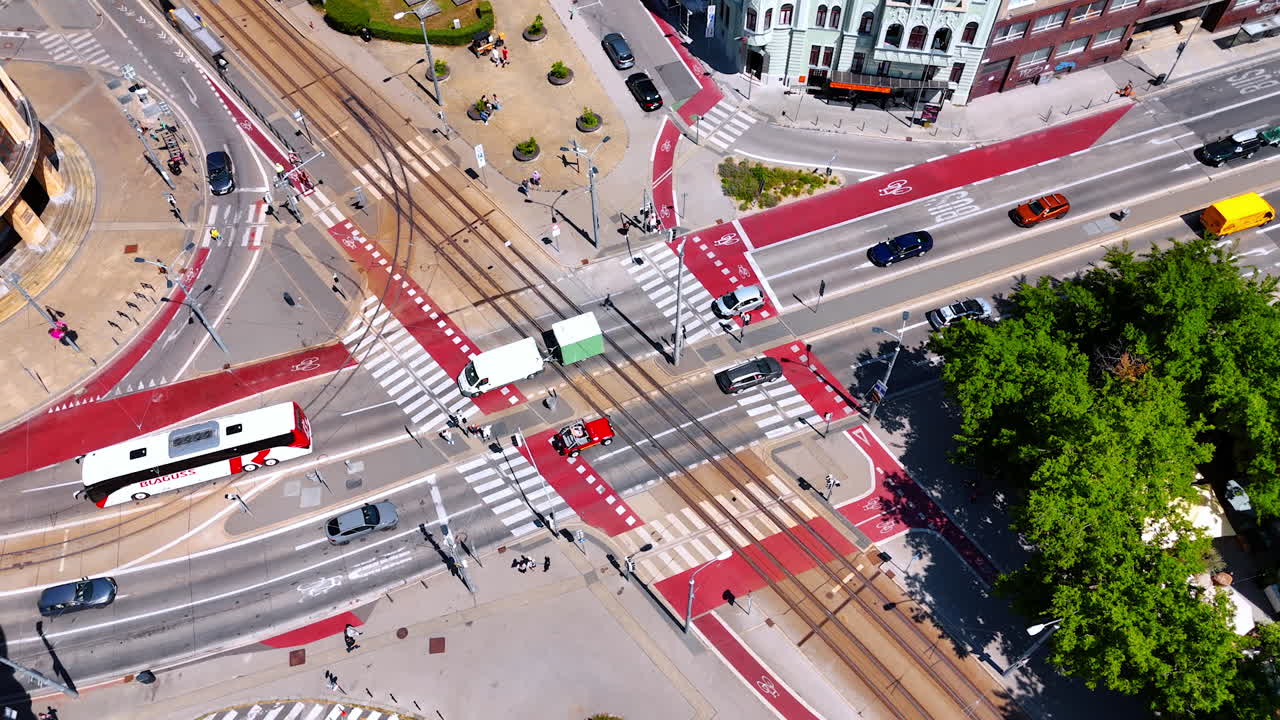 Transport moving by the main road in the crossroad with red marks. Aerial perspective on the traffic in the modern city.