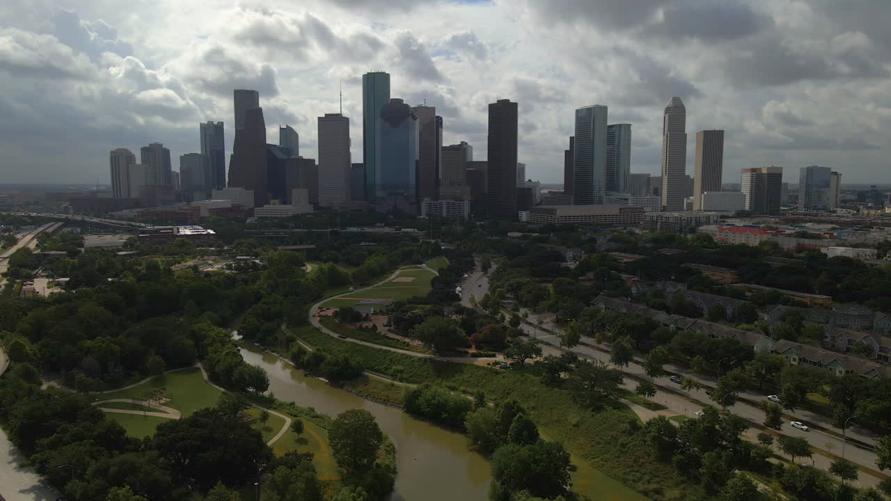 tomada aérea de houston, texas invirtiendo y elevándose sobre el parque de la ciudad