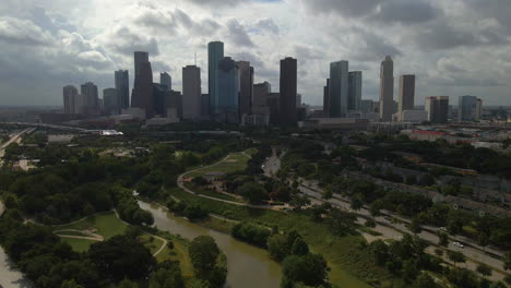 Aerial-Shot-of-Houston,-Texas-Reversing-and-Rising-Over-City-Park