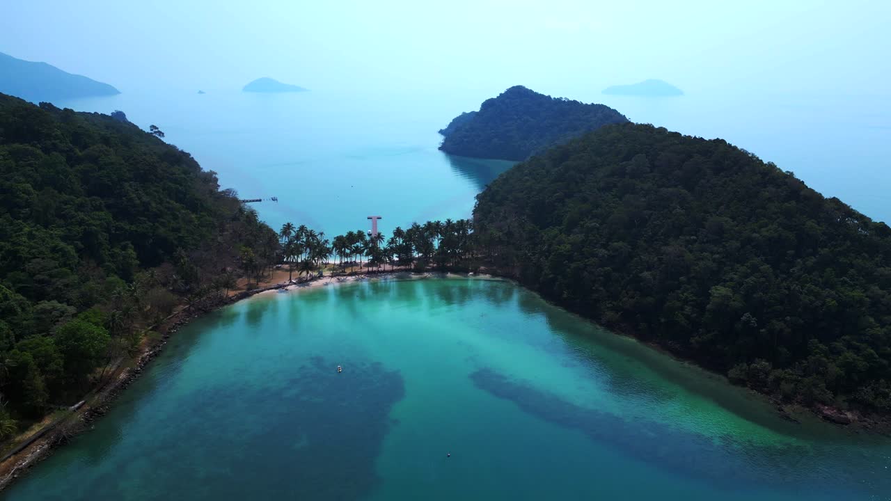 Scenic aerial view of lush green hills and turquoise waters on Koh Chang Ngam Island. Wonderful aerial view flight static tripod hovering drone