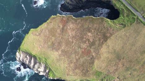 aerial drone shot of the coastal kilkee cliffs of ireland, panning over the countryside irish landscape