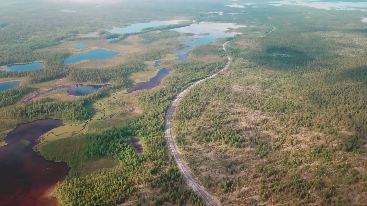 Ujęcie dronem z ruchem w przód i opuszczaniem kamery, przedstawiające duży park narodowy w północnej Finlandii.