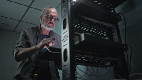 técnico de red que trabaja en una sala de servidores