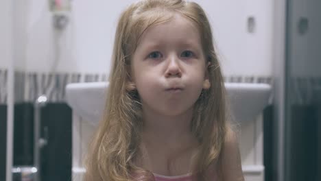 cute-girl-with-blue-eyes-coughs-at-mirror-in-modern-bathroom