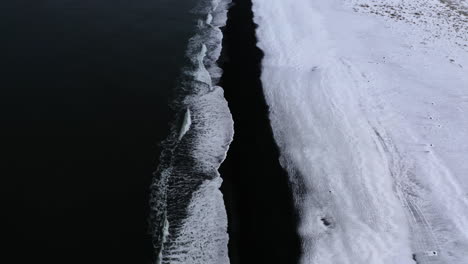 Aerial-view-tilting-over-the-Stokksnes-black-sand-beach,-foggy-winter-day-in-Iceland