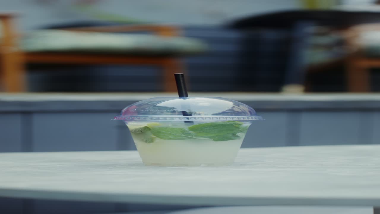 손은 밖에서 상쾌한 레모네이드 음료를 들고 있습니다.