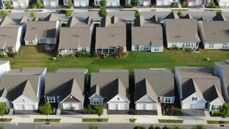 slow aerial tilt up revealing identical homes in suburban america, usa, identical homes in summer sunlight