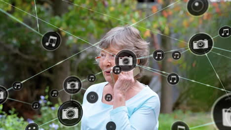 animación de una red de iconos conectados en círculos sobre una mujer caucásica anciana que usa un teléfono inteligente
