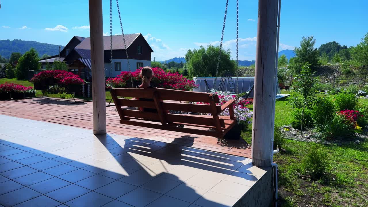 Serene Swinging Moments: A Tranquil Retreat Surrounded by Flowers and Nature's Beauty, Perfect for Relaxation and Reflection Under a Bright Blue Sky